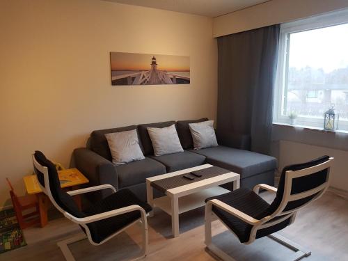 a living room with a couch and chairs and a table at Sweet family apartments Hamina in Hamina
