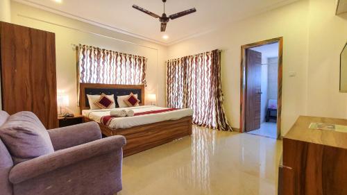 a bedroom with a bed and a couch and a chair at Rainforest Resort and Spa, Igatpuri -Nature's Luxury Awaits in Igatpuri