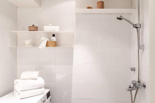 a white bathroom with a shower and white towels at Roost Laivasto 12 in Helsinki