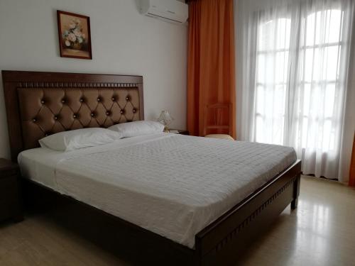 ein Schlafzimmer mit einem großen Bett in einem Zimmer mit Fenstern in der Unterkunft Hotel Paradise in Vassilias