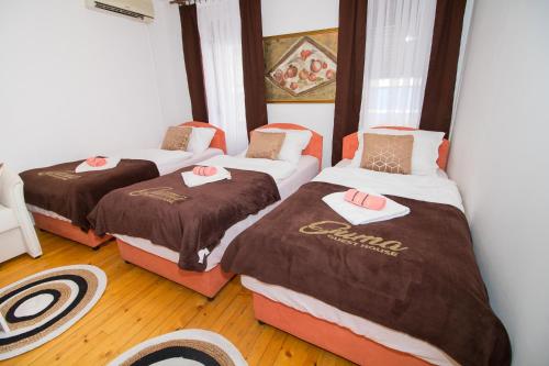 3 camas en una habitación con suelo de madera en Pansion Guma Mostar, en Mostar