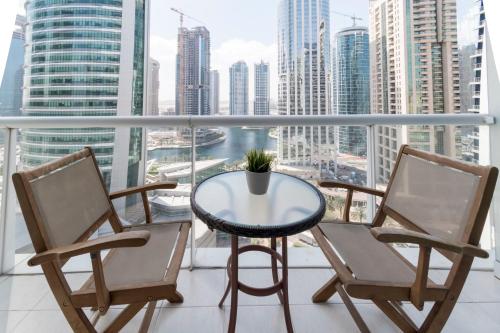 a table and chairs on a balcony with a view of a city at GuestReady - Hibernate Hideout in Dubai