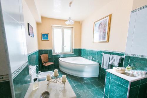 a bathroom with a tub and a toilet and a sink at B&B Villa Alba in Messina