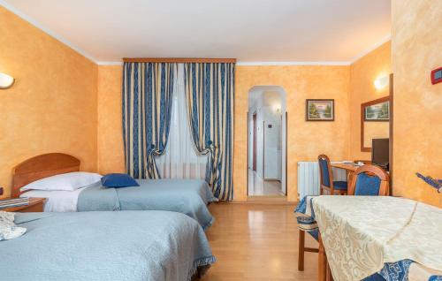 a hotel room with two beds and a table and chairs at Apartments and Rooms Laura in Pazin