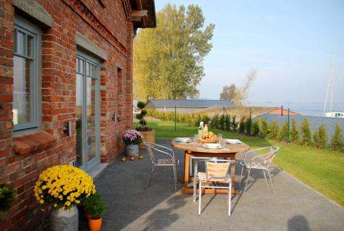 un patio con mesa y sillas en el lateral de una casa en Ferienhaus am Hafen, en Stahlbrode