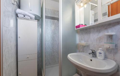 a white bathroom with a sink and a shower at Apartments and Rooms Laura in Pazin