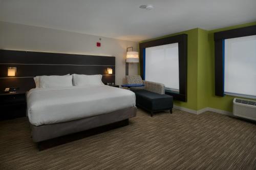 a hotel room with a large bed and a chair at Holiday Inn Express Lawrence by IHG in Lawrence