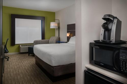a hotel room with a bed and a tv at Holiday Inn Express Lawrence by IHG in Lawrence