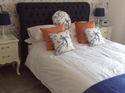a bed with blue and white pillows on it at Cwmllechwedd Fawr CYF in Llanbister
