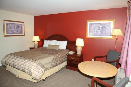 a hotel room with a bed and a table at Saxony Motel in Chatham