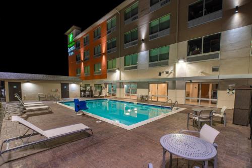 uma piscina em frente a um hotel à noite em Holiday Inn Express & Suites - Moses Lake, an IHG Hotel em Moses Lake