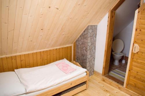 um pequeno quarto com uma cama e um WC em CHATA JURAJ em Mlynky 