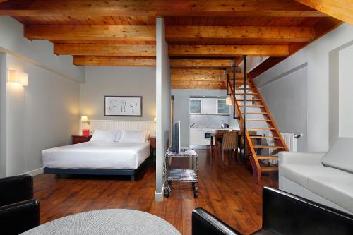 Apartamentos HG Cerler في سيرلير: غرفة نوم بسرير ودرج في غرفة