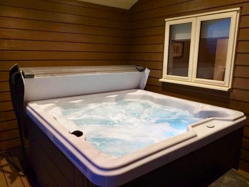 een jacuzzi in een kamer met een raam bij Waterside Lodges Cambridge in Cambridge