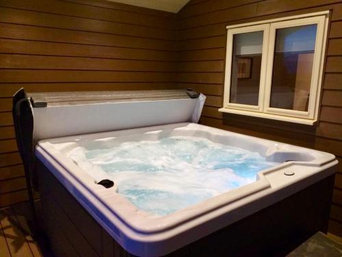 a jacuzzi tub in a room with a window at Waterside Lodges Cambridge in Cambridge