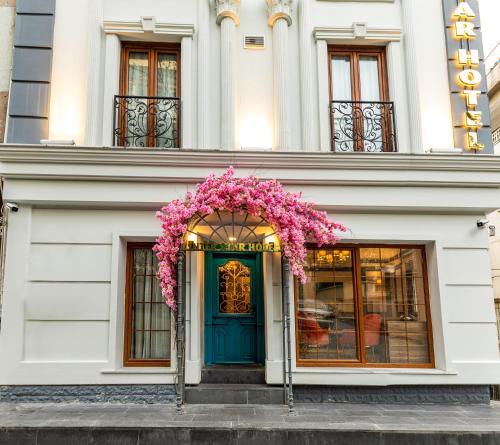a white building with a blue door with pink flowers at Interstar Hotel in Istanbul