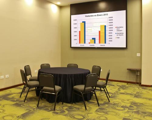 a conference room with a table and chairs and a screen at Holiday Inn Express & Suites Mexicali by IHG in Mexicali