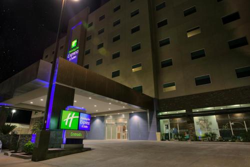 a building with a sign in front of it at night at Holiday Inn Express & Suites Mexicali by IHG in Mexicali