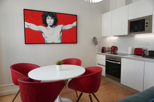 eine Küche mit einem weißen Tisch und roten Stühlen in der Unterkunft Lisbon Center Rua Augusta Modern Art Apartment in Lissabon
