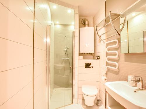 a bathroom with a shower and a toilet and a sink at VacationClub – Dworcowa 1A Apartament 3 in Szklarska Poręba