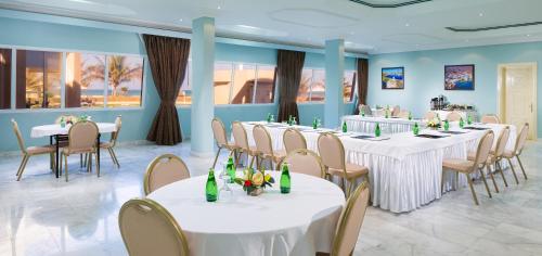 a conference room with white tables and chairs at Masira Island Resort in Ḩilf