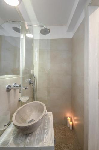 a bathroom with a sink and a tub with a mirror at Saint George Hotel in Naxos Chora