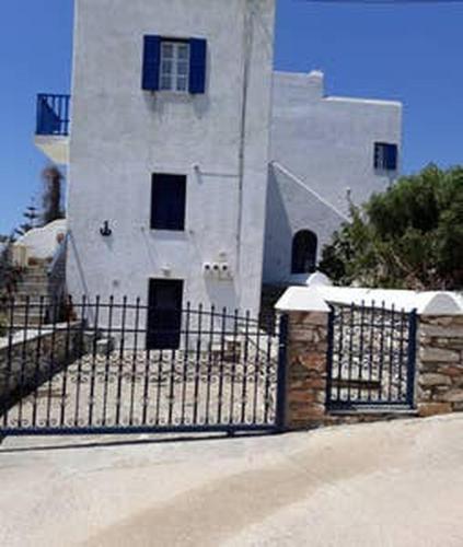 a building with a gate in front of a building at Village house in Paros in Drios