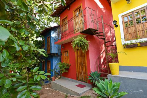 a colorful house with a red door and a balcony at Chalés Natora in Lençóis