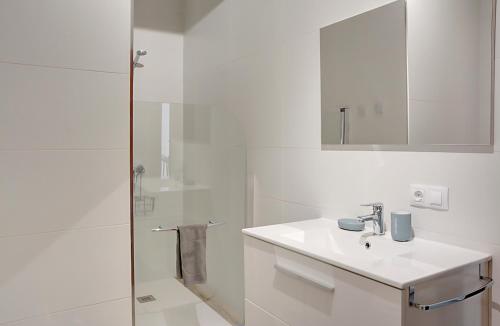 a white bathroom with a sink and a shower at Apartamento Murillo in Seville