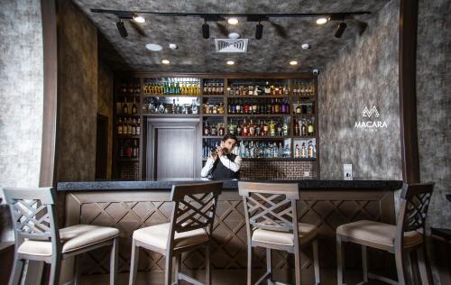 a woman standing behind a bar in a restaurant at Macara Sheki City Hotel in Sheki