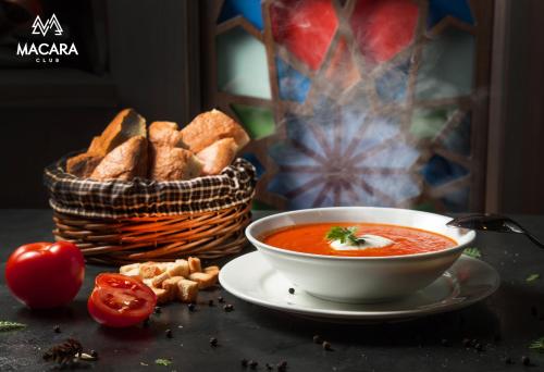 a bowl of soup and a basket of bread at Macara Sheki City Hotel in Sheki
