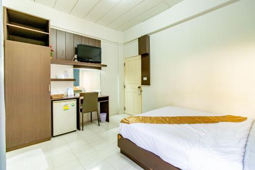 a bedroom with a bed and a desk and a kitchen at Riski Residence Bangkok-noi - Wasit Apartment in Bangkok
