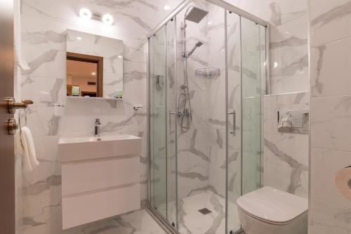 y baño con ducha, aseo y lavamanos. en Mountain View apartment 541, en Smolyan