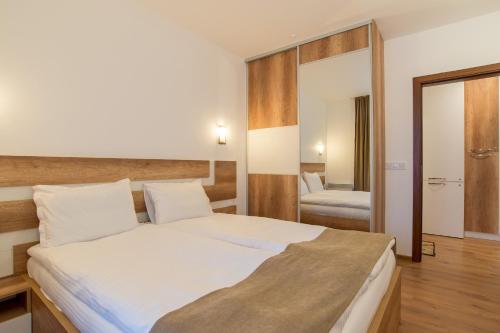 1 dormitorio con 1 cama grande y espejo en Mountain View apartment 541 en Smolyan