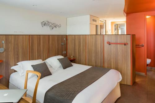 a bedroom with a large bed in a room at Terre de Provence Hôtel & Spa in Le Pontet