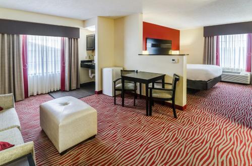 a hotel room with a bed and a table and chairs at Holiday Inn Express Hotel & Suites Vinita by IHG in Vinita