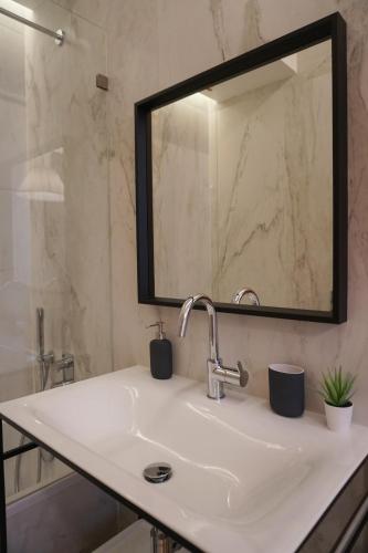 a bathroom with a sink and a mirror at Lisbon Center Rua Augusta Modern Art Apartment in Lisbon