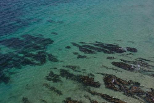 an aerial view of the ocean with rocks in the water at JUST-4-YOU! amazing sea views, WIFI, fully air-conditioned, king bed in Vincentia