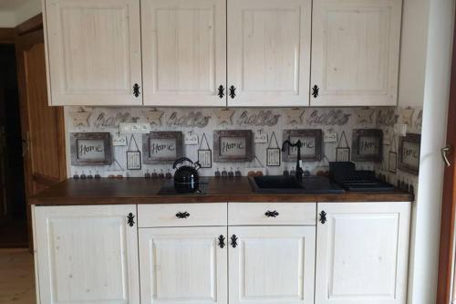 a kitchen with white cabinets and a counter top at Blisko Krupówek a cicho i spokojnie II in Zakopane