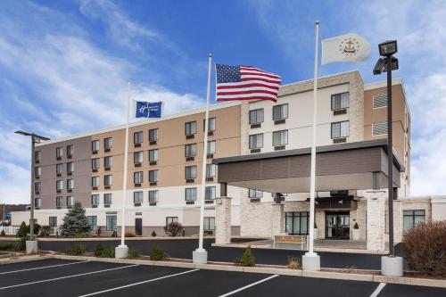 a hotel with two flags on top of it at Holiday Inn Express Hotel & Suites Providence-Woonsocket by IHG in Woonsocket