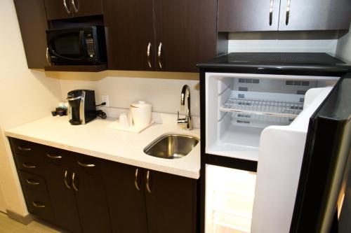 a small kitchen with a sink and a microwave at Holiday Inn Hotel & Suites Red Deer by IHG in Red Deer