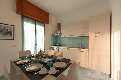 ミントゥルノにあるCapri Apartmentのキッチン(ダイニングルームテーブル、皿、ボウル付)