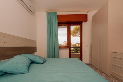 ミントゥルノにあるCapri Apartmentのベッドルーム1室(青い枕のベッド1台、窓付)