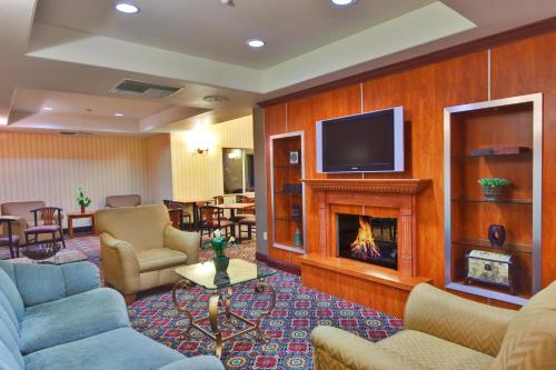 a hotel lobby with a fireplace and a tv at Holiday Inn Express Hotel & Suites Ontario Airport-Mills Mall, an IHG Hotel in Rancho Cucamonga