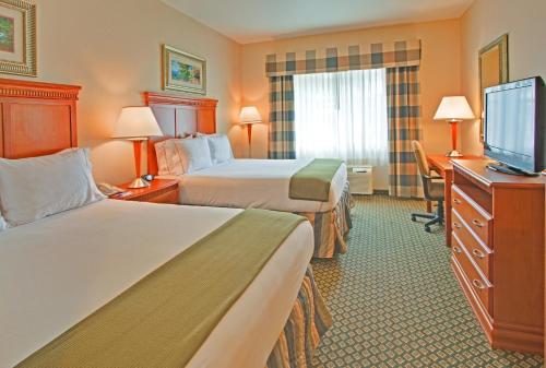 um quarto de hotel com duas camas e uma televisão de ecrã plano em Holiday Inn Express Hotel & Suites Ontario Airport-Mills Mall, an IHG Hotel em Rancho Cucamonga