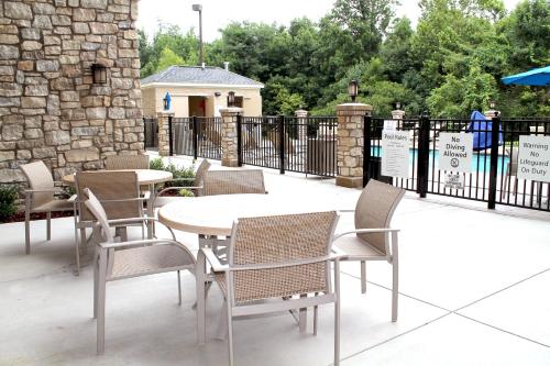 een patio met een tafel en stoelen en een hek bij Holiday Inn Express & Suites Paducah West, an IHG Hotel in Paducah