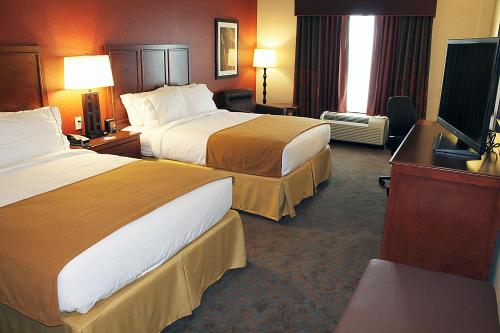 a hotel room with two beds and a flat screen tv at Holiday Inn Express & Suites Paducah West by IHG in Paducah