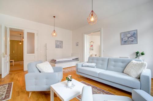 ein Wohnzimmer mit einem blauen Sofa und einem Tisch in der Unterkunft Bishop Apartments in Brünn