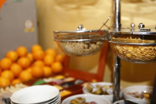 two glasses filled with food on a table with oranges at Hotel Estense in Modena