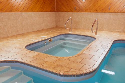 a jacuzzi tub in a room with a wooden ceiling at Holiday Inn Express Hotel & Suites Wauseon, an IHG Hotel in Wauseon